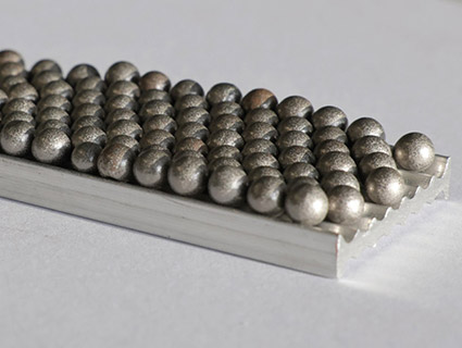 Le matériau composite HoverLIGHT est constitué d'un noyau en mousse d'aluminium avec des sphères creuses encapsulées. Leurs effets d'amortissement sont comparables à ceux du magnésium. Source : Fraunhofer IWU